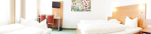 a bedroom with two white beds and a television at Hotel-Restaurant Roter Ochsen in Lauchheim