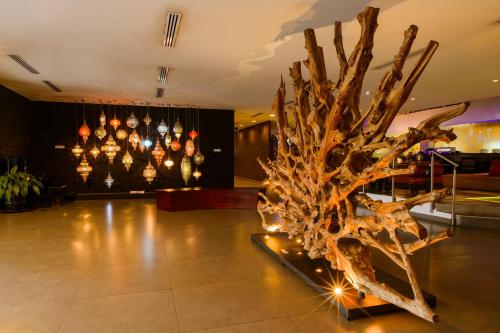 a sculpture of a tree in a room with lights at Riande Aeropuerto Hotel Casino in Tocumen