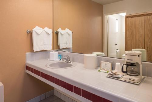 a bathroom with a sink and a mirror at Laurel Inn & Conference Center in Salinas