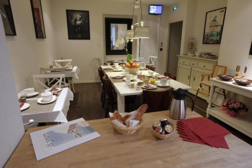 a living room with a table and a kitchen at Hôtel Alizé in Cannes