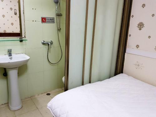 a small bathroom with a sink and a shower at Astronaut's Hotel in Hong Kong