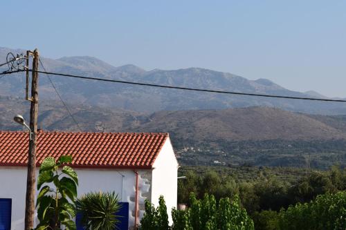 a white house with mountains in the background at Venetian Cistern Villa in Kalamítsion Alexándrou