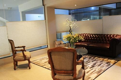 a living room with a couch and a table and chairs at Hotel Las Terrazas Business in Chillán