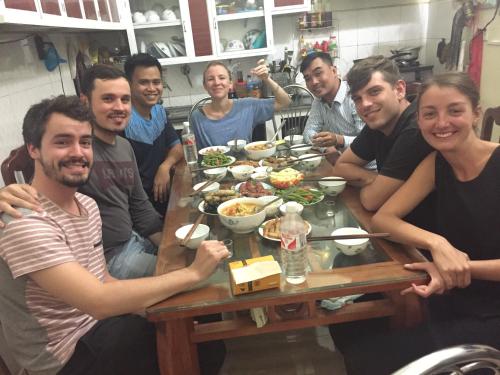 a group of people sitting around a table with food at Cao Bang Eco Homestay in Cao Bằng