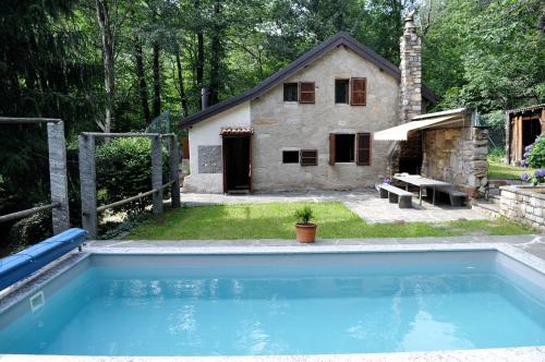 a large swimming pool in front of a house at Rustico Gola di Lago in Lelgio