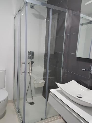 y baño con ducha acristalada y lavamanos. en Playa Elisa Bay MP009, en Torre de la Horadada