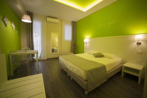 a green bedroom with a bed and a table at Residence del sole Manfredonia in Manfredonia