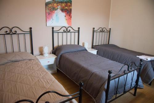 メッシーナにあるB&B Caffelletto - Papardoのベッドルーム1室(ベッド2台付)が備わります。壁には絵画が飾られています。