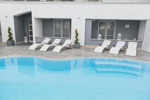 a group of lounge chairs and a swimming pool at Residence del sole Manfredonia in Manfredonia