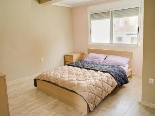 a bedroom with a large bed with a window at La Mata Apartments in Torrevieja