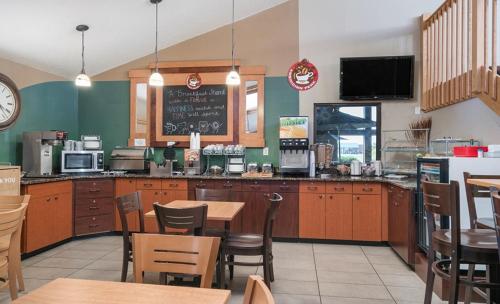 a restaurant with a counter and tables and chairs at AmericInn by Wyndham Grafton in Grafton