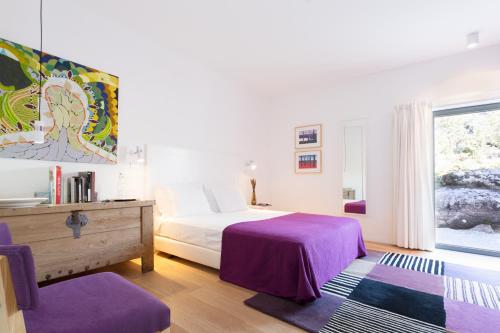 una camera da letto con un letto con lenzuola viola e una finestra di Quinta das Lavandas a Castelo de Vide