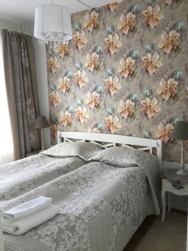 sypialnia z łóżkiem i tapetą w kwiaty w obiekcie Finnclub Voyage Luxury Appartment w mieście Laukaa