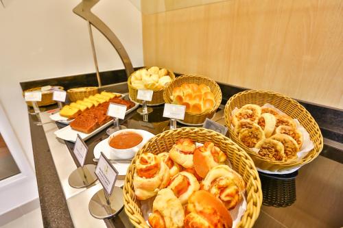 a buffet with baskets of pastries and other foods at Transamerica Fit Jacareí in Jacareí