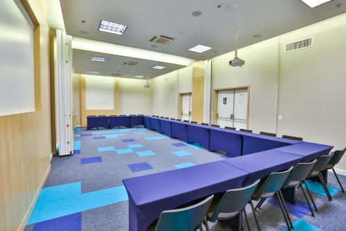 a large conference room with blue tables and chairs at Transamerica Fit Jacareí in Jacareí