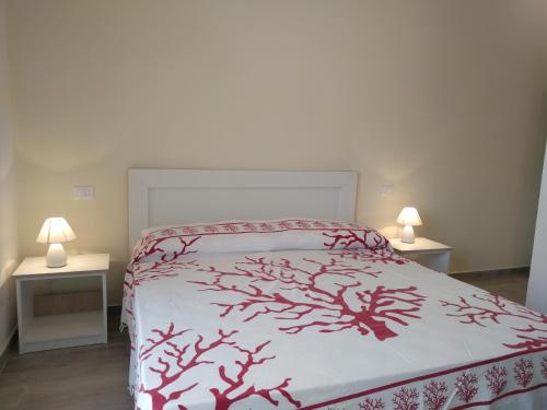 una camera con un letto con una coperta rossa e bianca di Camere Mare Manu a Porto Cesareo