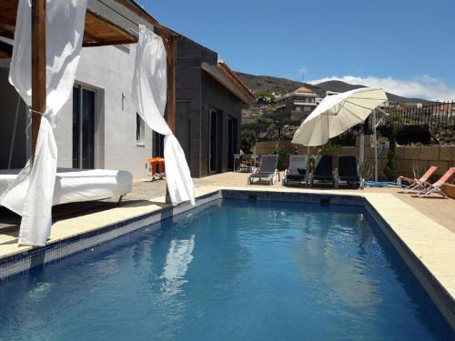 a swimming pool with white drapes on a house at LUXURY VILLA Atlantico Views in Candelaria