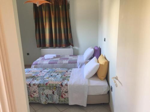 two beds in a small room with a door open at Assos Villa in Káto Ássos