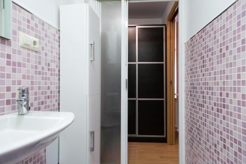 y baño con lavabo y ducha con azulejos rosados. en Suite Loft Laurel, en Logroño