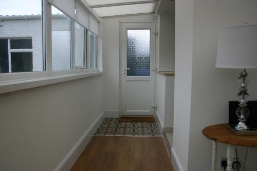 a hallway with a door and a window at Beach Links in Prestatyn