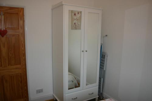 a white cabinet in the corner of a room at Beach Links in Prestatyn