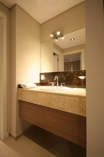 a bathroom with a sink and a mirror at Cumeló Cariló in Carilo