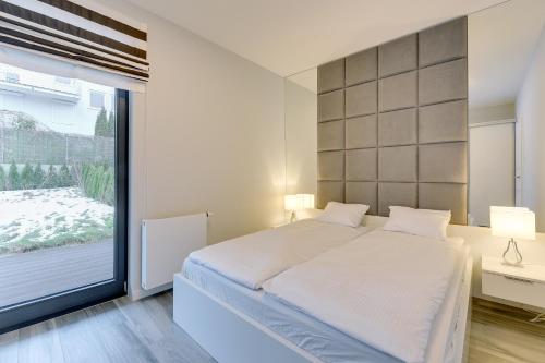 Łóżko lub łóżka w pokoju w obiekcie Rivus - Baltica Apartments