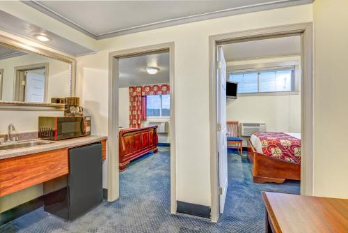 a room with a kitchen and a bedroom with a bed at Spark by Hilton Portland Airport Maine Mall in South Portland