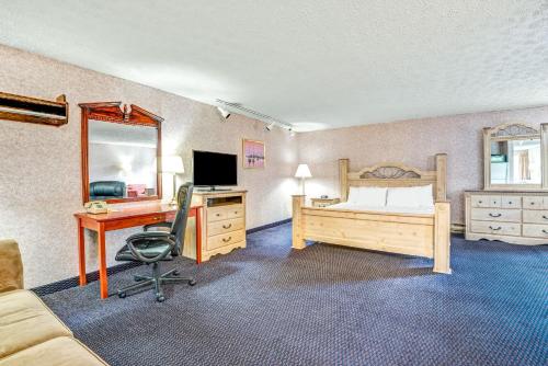 a bedroom with a bed and a desk with a computer at Spark by Hilton Portland Airport Maine Mall in South Portland
