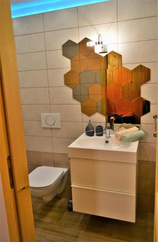 a bathroom with a sink and a toilet and a mirror at Sleeping with the bees Kozjak in Kobarid