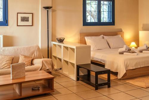 ein Schlafzimmer mit einem Bett und einem Sofa in der Unterkunft Villa Coin de Paradis in Syvota