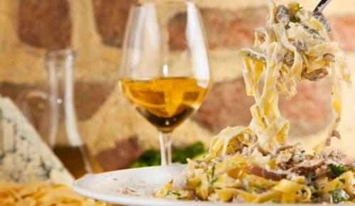 a plate of pasta and a glass of wine at Agriturismo Cannavota in Follonica