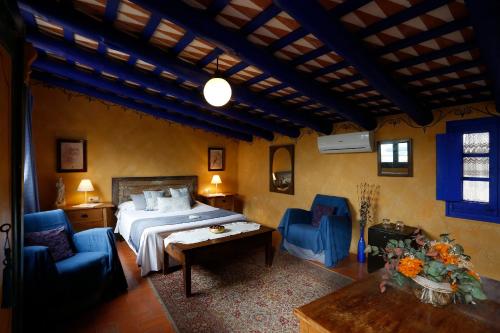 a bedroom with a bed and two blue chairs at Hostal Blau in Peratallada