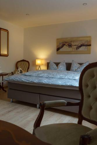 a bedroom with a large bed with blue sheets at Zum Fuchsbau in Hettstadt