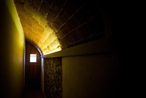 a dark hallway with a door and a brick wall at Marakasa B&B in Sant Antoni de Calonge