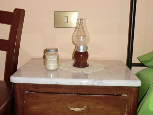 a lamp and a candle on a nightstand next to a bed at Residenza Frenguelli in Spello