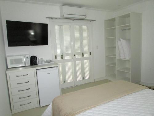 a bedroom with a bed and a desk and a microwave at San Clemente Residence in Gramado