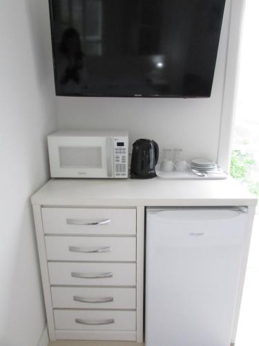 a microwave oven sitting on top of a white cabinet at San Clemente Residence in Gramado