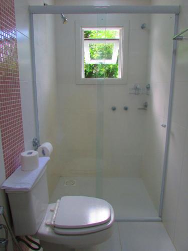 a bathroom with a shower and a toilet and a window at San Clemente Residence in Gramado