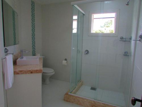 a bathroom with a shower and a toilet and a window at San Clemente Residence in Gramado