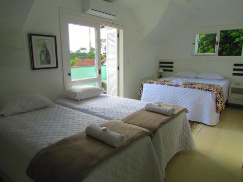 a bedroom with two beds with towels on them at San Clemente Residence in Gramado