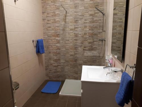 a bathroom with a white sink and a shower at D Bay Apartments in St. Paul's Bay