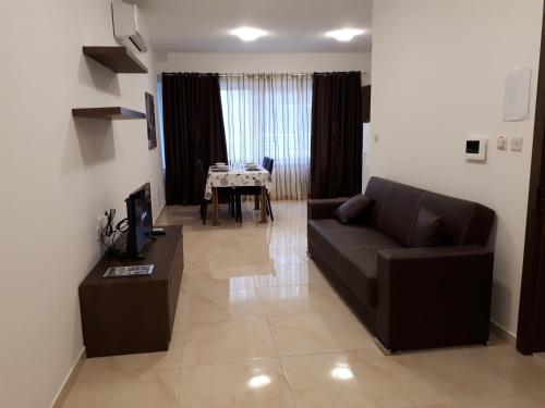 a living room with a couch and a table at D Bay Apartments in St. Paul's Bay