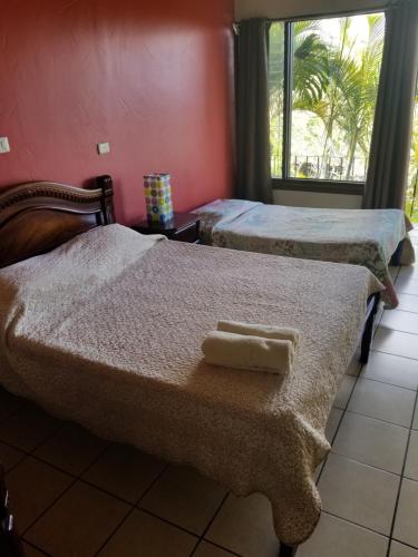 two beds with towels on them in a room at Hotel Monte Campana Heredia in Birrí