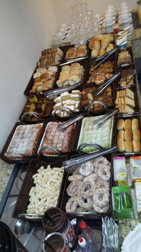 una tavola piena di diversi tipi di ciambelle e prodotti da forno di Vila Santa Hotel a Aparecida