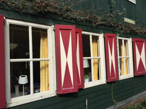 two red and white windows on a green building at Landgoed De Heezeberg in Diever
