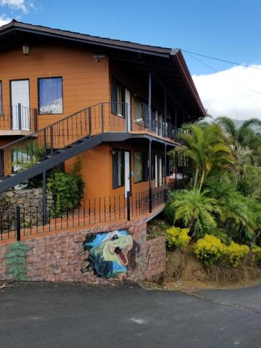 a house with a painting on the side of it at Hotel Monte Campana Heredia in Birrí