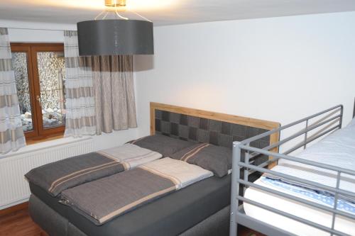 ein kleines Schlafzimmer mit einem Bett und einem Fenster in der Unterkunft Ferienwohnung Bergler in Trins