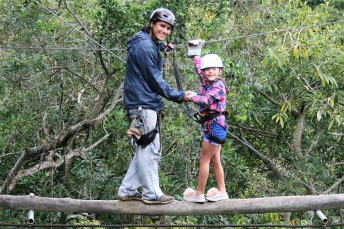 a man and a little girl standing on a suspension bridge at Hotel Monte Campana Heredia in Birrí
