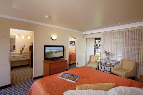 a hotel room with a bed and a flat screen tv at Best Western Garden Inn in Santa Rosa